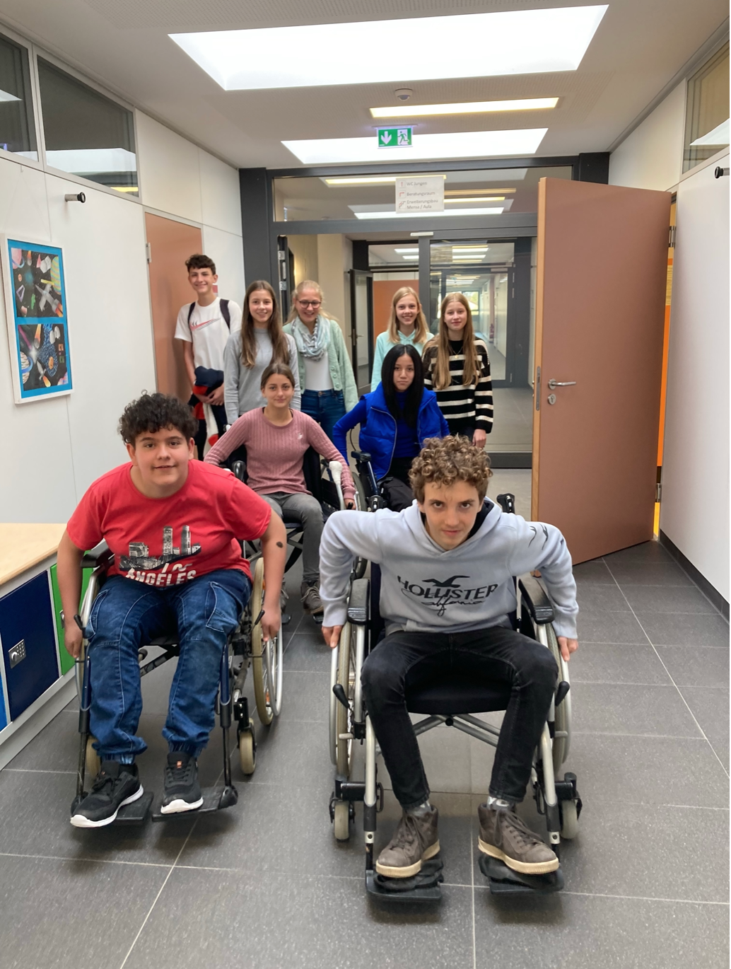 Verschiedene Schülerinnen und Schüler im Rollstuhl