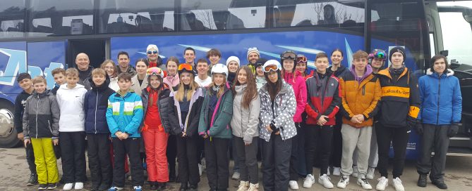 Auf diesem Bild sind Schülerinnen und Schüler vor einem Bus zu sehen.