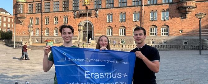 Schüler mit Flagge vor Gebäude