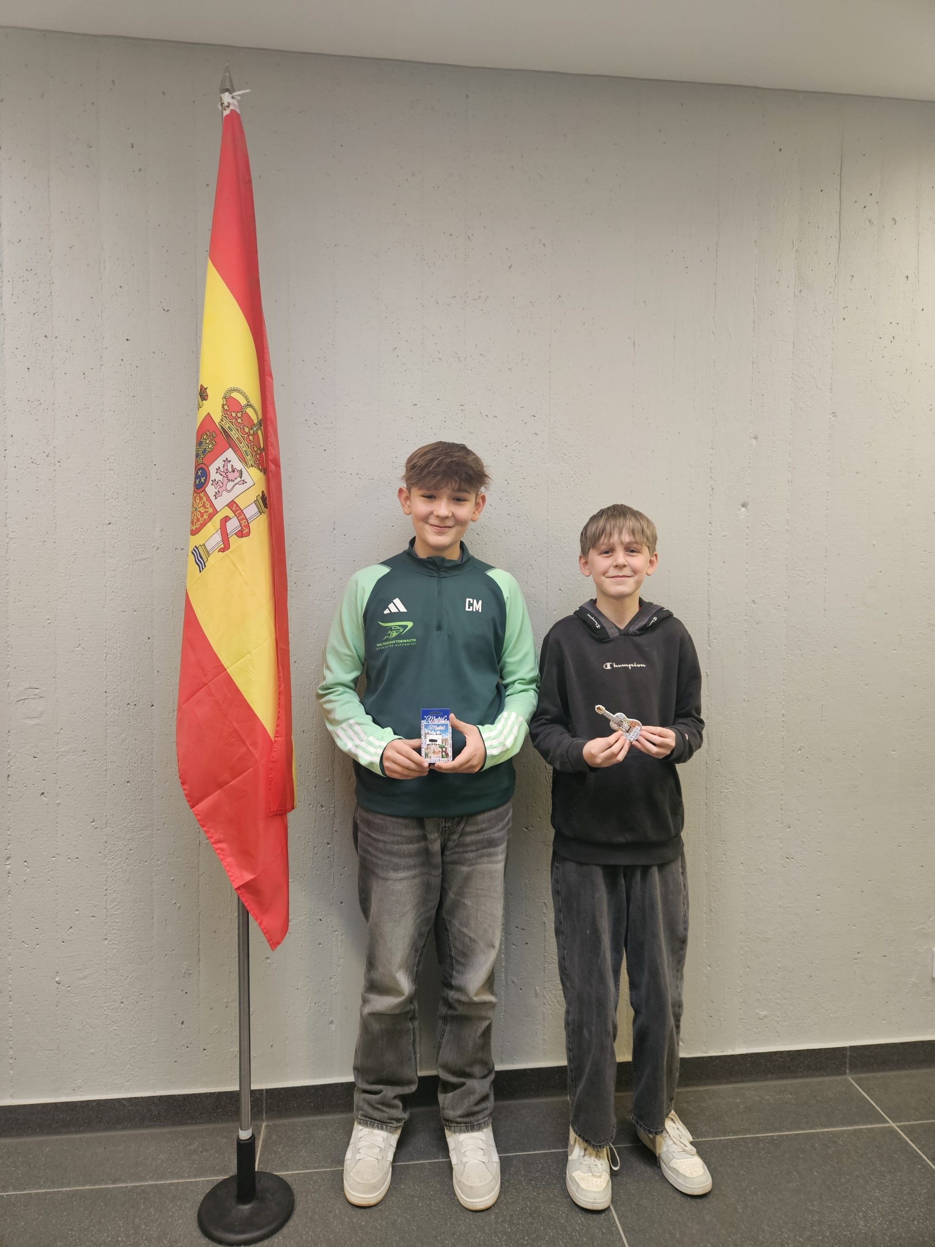 Schüler mit Preis vor Spanischflagge
